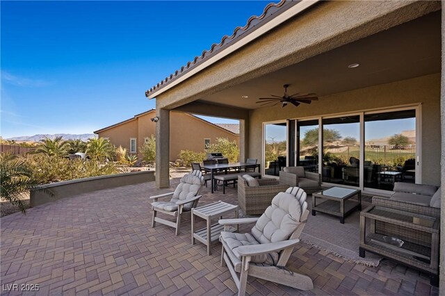 view of patio featuring area for grilling, ceiling fan, a mountain view, and outdoor lounge area