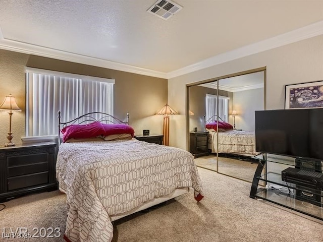 bedroom featuring ornamental molding, carpet floors, and a closet