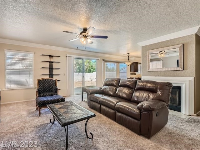 living room featuring a textured ceiling, ceiling fan, ornamental molding, and light carpet