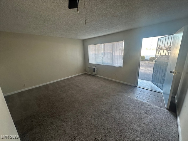 interior space with a textured ceiling, a wall mounted air conditioner, dark carpet, and plenty of natural light