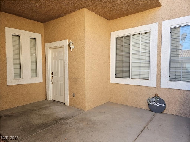 view of exterior entry featuring a patio