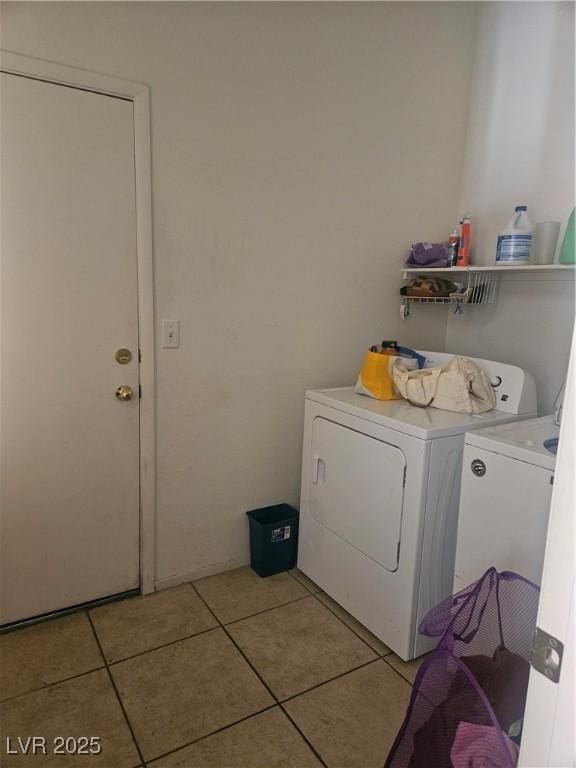 clothes washing area with light tile patterned floors and separate washer and dryer