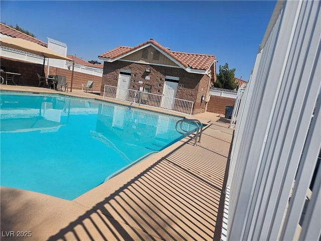 view of swimming pool featuring a patio and an outbuilding