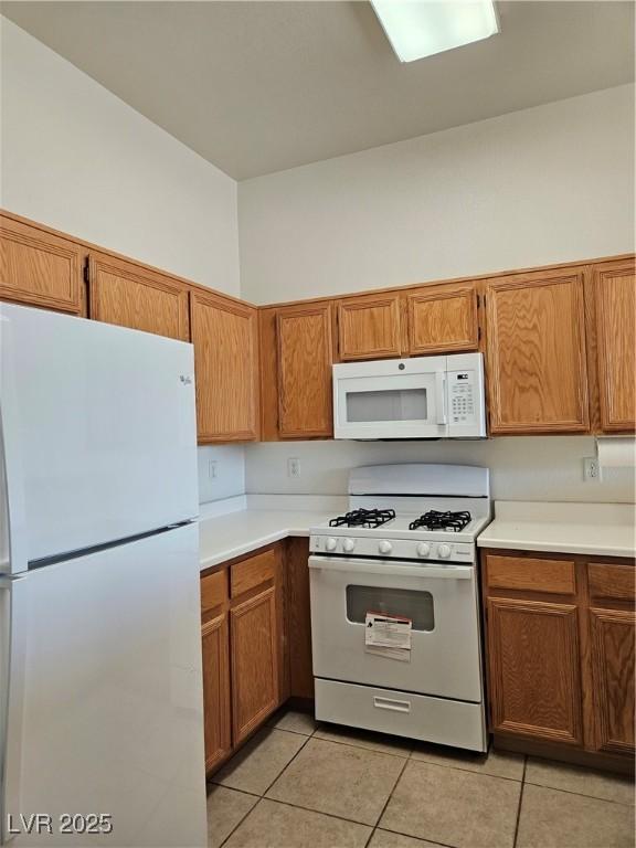 kitchen with white appliances and light tile patterned floors