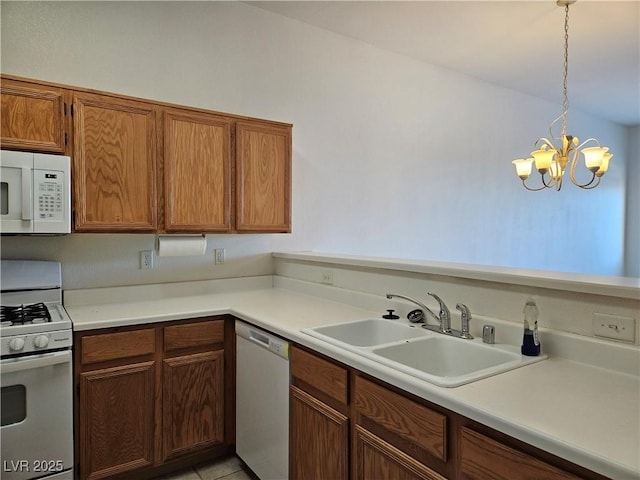 kitchen with white appliances, pendant lighting, a notable chandelier, light tile patterned flooring, and sink