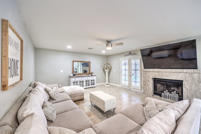 living room featuring ceiling fan, french doors, and a tile fireplace