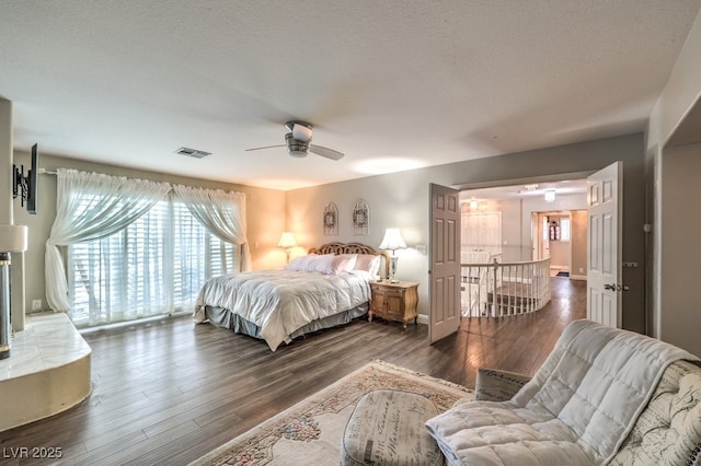 bedroom featuring a textured ceiling, ceiling fan, and dark hardwood / wood-style floors