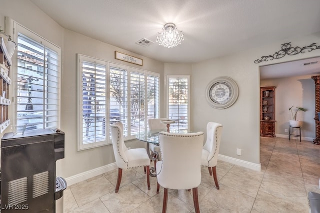 tiled dining area featuring an inviting chandelier