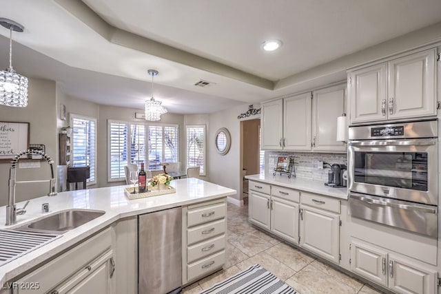 kitchen featuring oven, white cabinetry, and pendant lighting