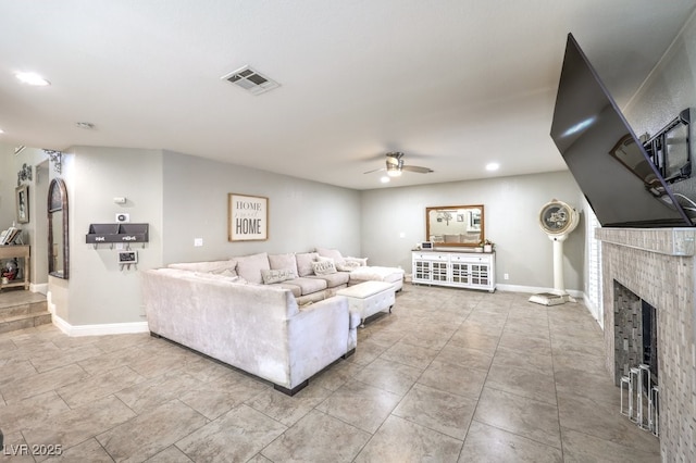 living room featuring a tile fireplace and ceiling fan