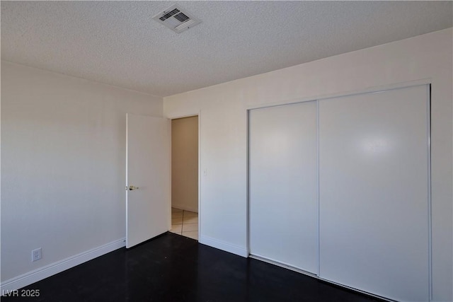 unfurnished bedroom featuring a textured ceiling and a closet