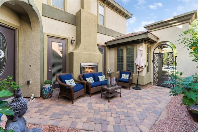 view of patio with an outdoor living space with a fireplace