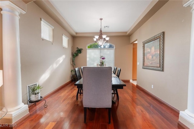 dining room with ornate columns, plenty of natural light, and dark hardwood / wood-style floors