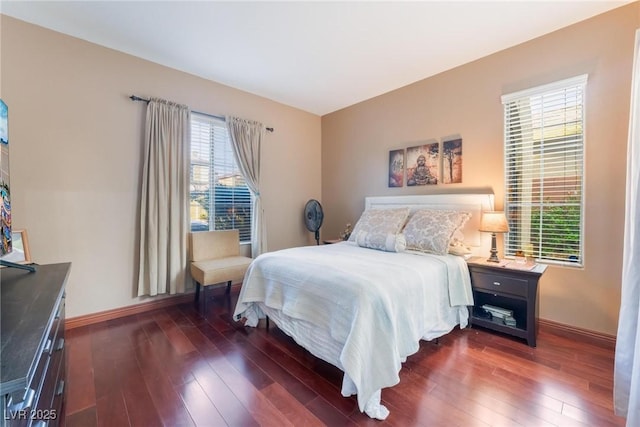 bedroom with dark hardwood / wood-style flooring and multiple windows