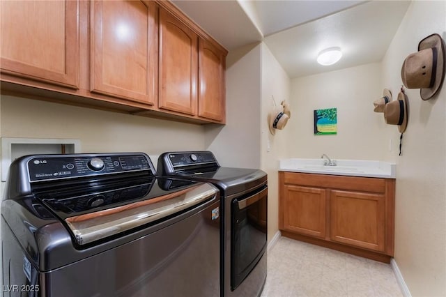 clothes washing area featuring sink, cabinets, and washing machine and clothes dryer