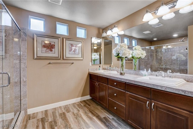 bathroom with vanity, a shower with shower door, and hardwood / wood-style flooring