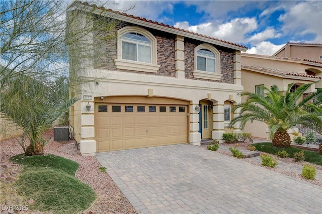 mediterranean / spanish-style house featuring a garage and central air condition unit