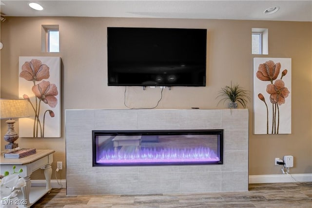 details featuring wood-type flooring and a tile fireplace