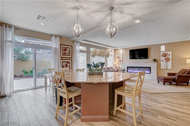 dining space featuring an inviting chandelier, light hardwood / wood-style floors, and a wealth of natural light