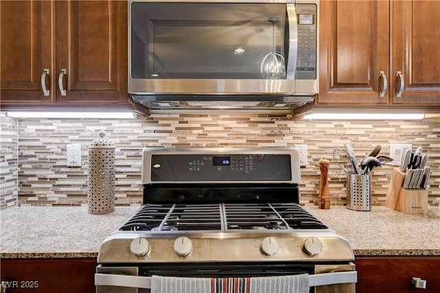 kitchen featuring light stone countertops, appliances with stainless steel finishes, and decorative backsplash