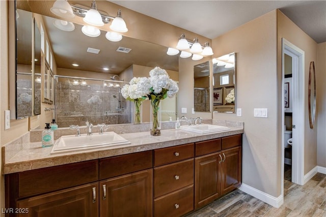 bathroom with toilet, hardwood / wood-style flooring, an enclosed shower, and vanity