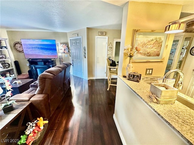 living room featuring a textured ceiling and dark wood-type flooring