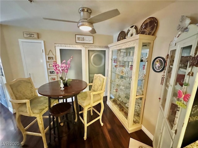 dining space with ceiling fan and dark hardwood / wood-style flooring