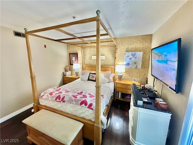 bedroom with dark wood-type flooring and a textured ceiling