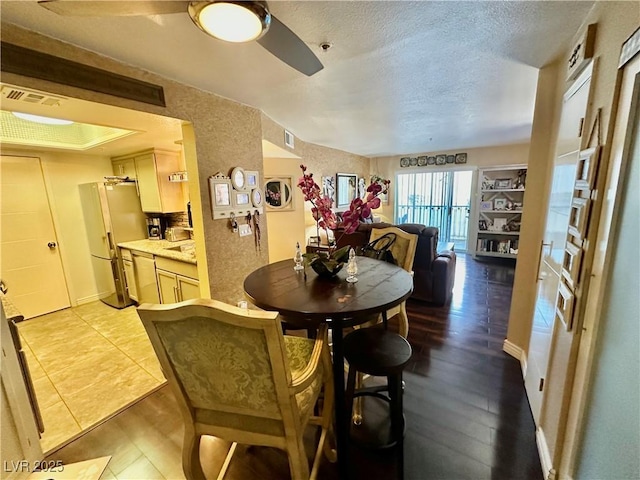 dining room featuring ceiling fan and a textured ceiling