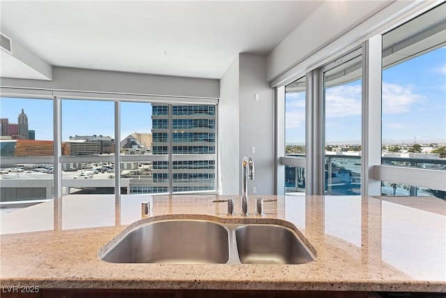 kitchen featuring sink and light stone counters