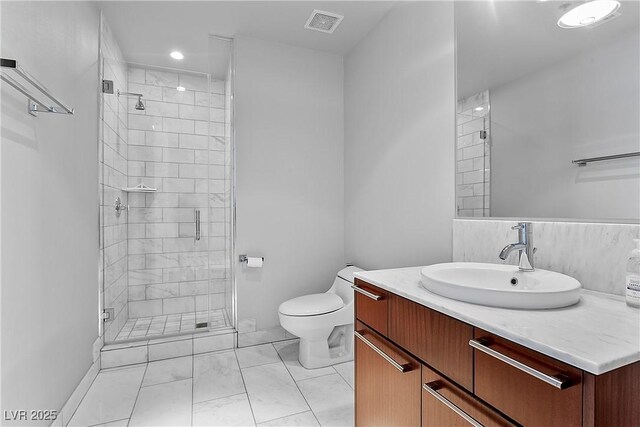 bathroom with toilet, vanity, and a shower with shower door