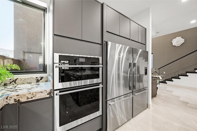 kitchen featuring appliances with stainless steel finishes and light stone countertops