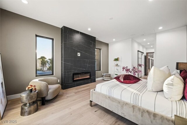 bedroom featuring a fireplace and light wood-type flooring