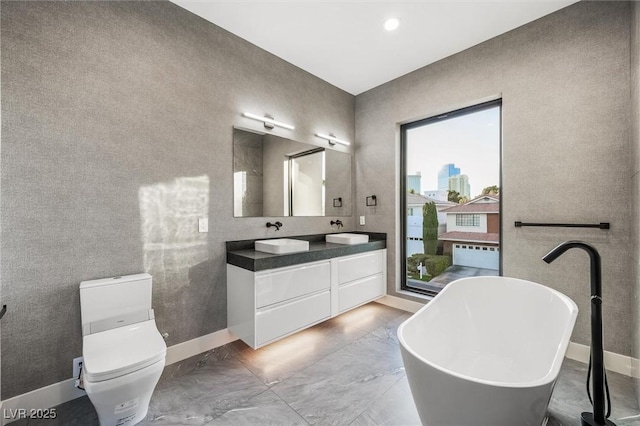 bathroom featuring toilet, vanity, a healthy amount of sunlight, and a bathtub