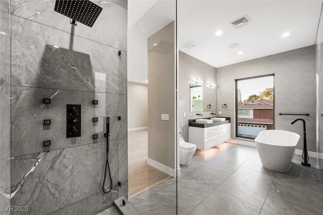 full bathroom featuring shower with separate bathtub, vanity, and toilet