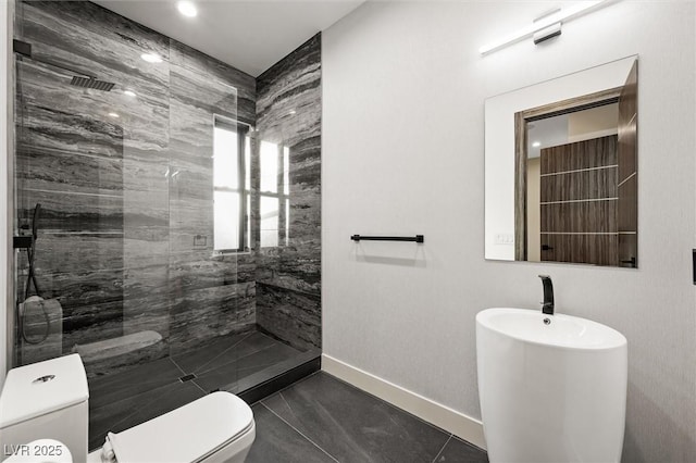 bathroom featuring tiled shower, tile patterned floors, and toilet