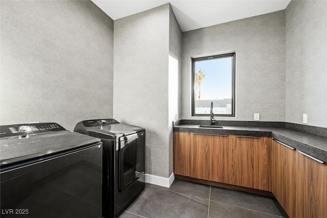 washroom featuring separate washer and dryer, cabinets, dark tile patterned flooring, and sink