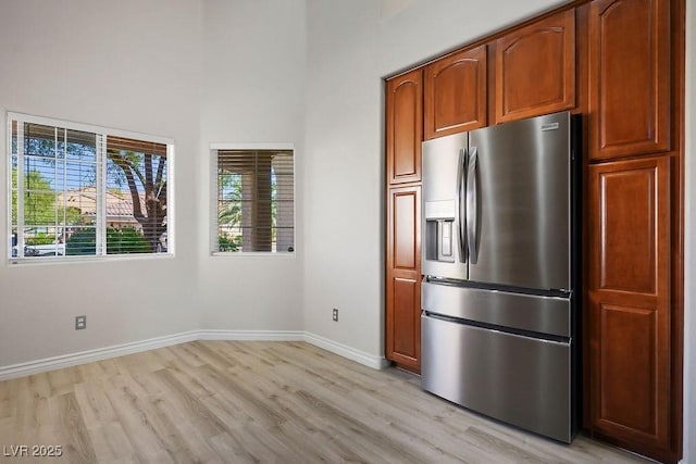 kitchen with stainless steel fridge and light hardwood / wood-style flooring