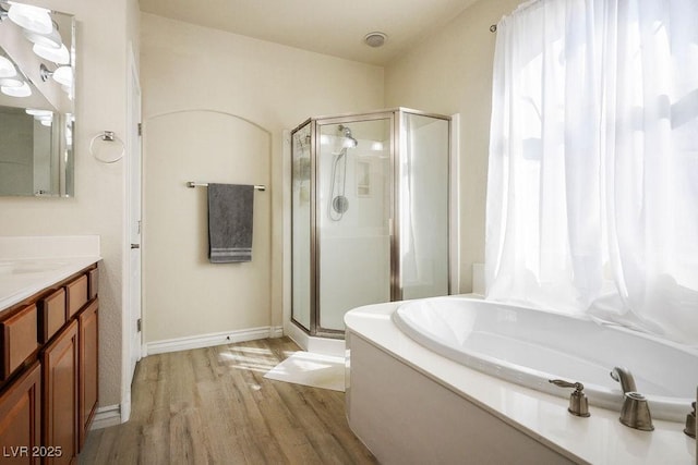 bathroom with hardwood / wood-style floors, separate shower and tub, and vanity