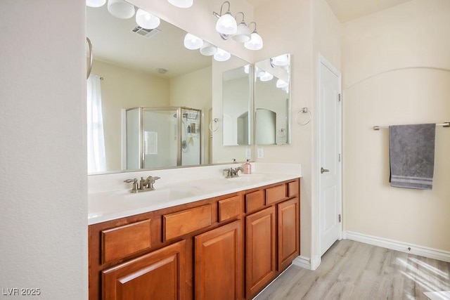 bathroom with a shower with door, wood-type flooring, and vanity