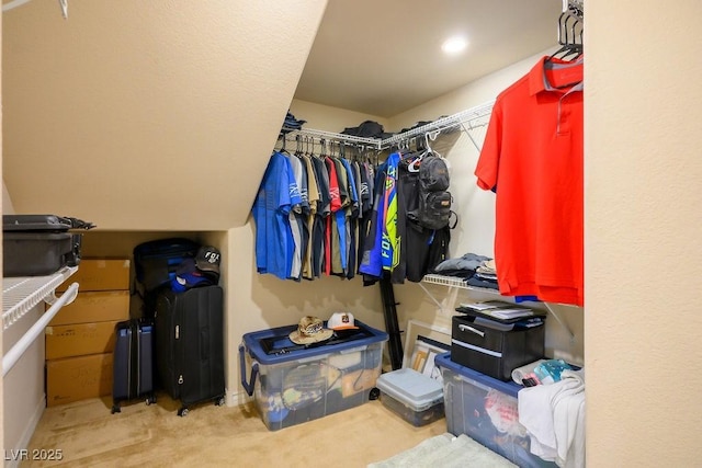 walk in closet featuring light colored carpet