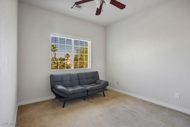 living area with light carpet and ceiling fan