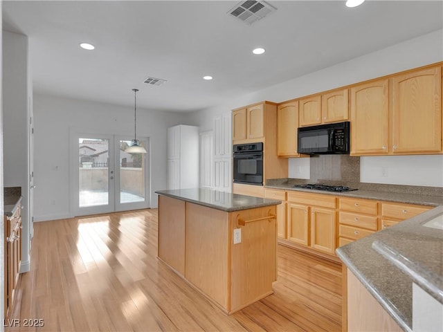 kitchen with black appliances, hanging light fixtures, french doors, light brown cabinetry, and a kitchen island