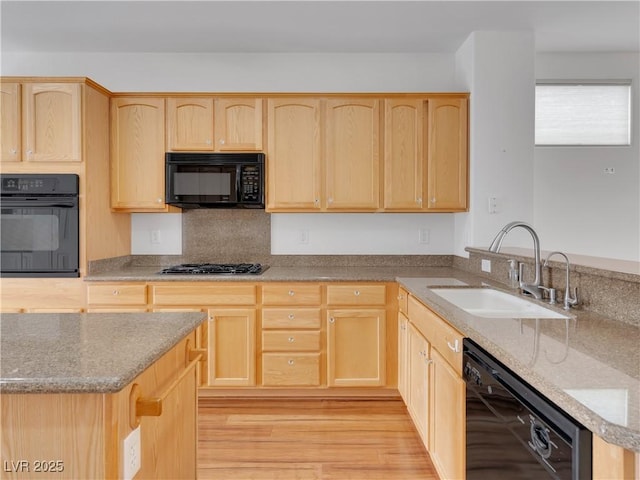 kitchen featuring light brown cabinetry, black appliances, and sink