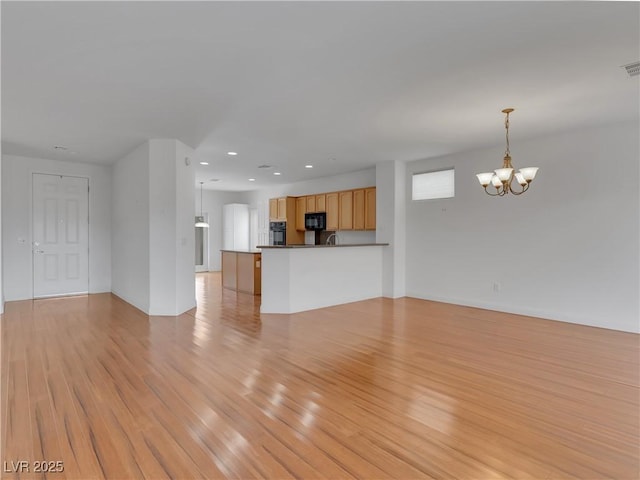 unfurnished living room with light hardwood / wood-style flooring and an inviting chandelier