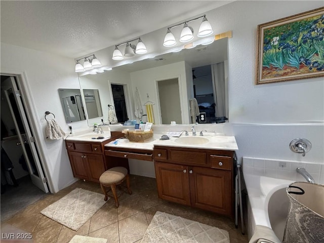 bathroom with vanity, tile patterned floors, a washtub, and a textured ceiling