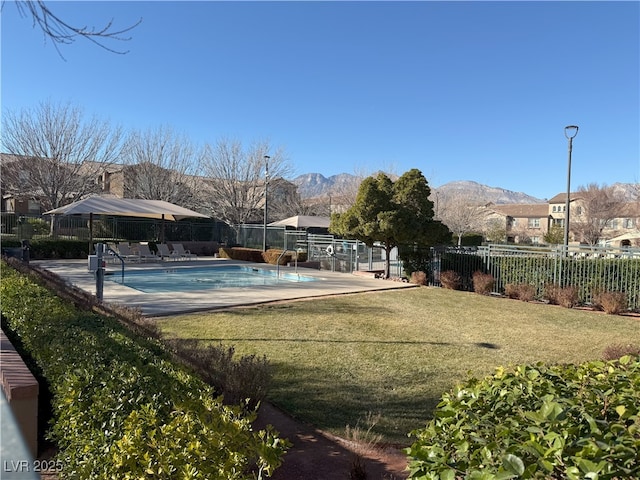 exterior space with a mountain view, a swimming pool, and a lawn