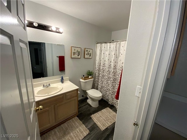 bathroom with toilet, a shower with shower curtain, vanity, and hardwood / wood-style floors