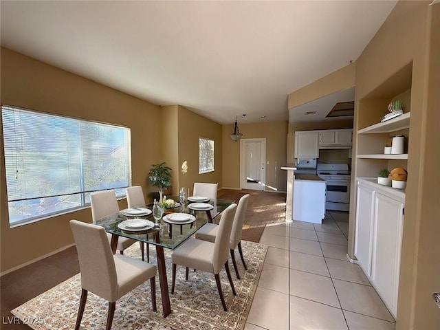 dining space featuring built in shelves and light tile patterned flooring