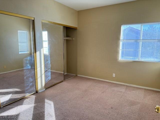 unfurnished bedroom featuring multiple windows, a closet, and carpet floors